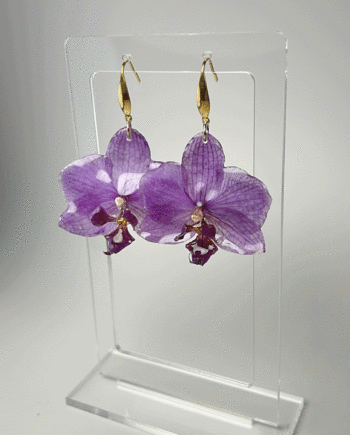 Preserved purple orchid earrings dipped in resin.